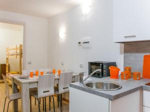 a kitchen with a sink and a table with chairs at Apartment Cervinia ski-in ski-out slopes in Breuil