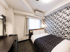 a hotel room with a bed and a desk at APA Hotel Kyoto Ekimae in Kyoto