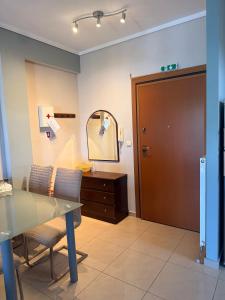 a dining room with a table and chairs and a mirror at Apartment near the circuit of Serres and centre!!! in Serres
