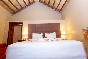 Un dormitorio con una cama grande con sábanas blancas. en Akagera Safari Camp, en Kigali