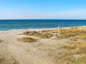 a sign on a sandy beach near the ocean at 5 person holiday home in Dannemare-By Traum in Dannemare +28 photos
