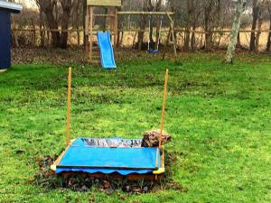 a blue bed in a field with a playground at 5 person holiday home in Dannemare-By Traum in Dannemare