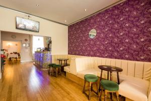 ein Wohnzimmer mit Sofa, Tisch und Stühlen in der Unterkunft Pearl Moore TA Canberra Hotel in Blackpool