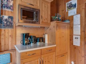 a kitchen with wooden cabinets and a microwave at Chalet in Mörtschach near Ski Slopes in Mörtschach