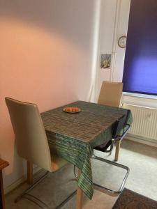 a dining room table with chairs and a plate of fruit on it at Romantisches ganzes Apartment Parkplatz Waschmaschine Kamin Terrasse Garten, Grill und Küche in Duisburg