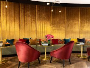 a dining room with red chairs and a table with pillows at Numa Brussels Royal Galleries in Brussels