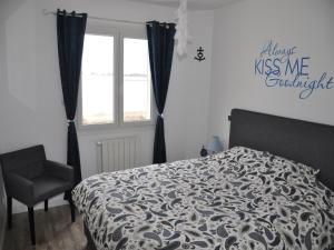 Un dormitorio con una cama y una silla y una ventana. en Villa in Le Grau du Roi near Flamingo Lagoon, en Le Grau-du-Roi