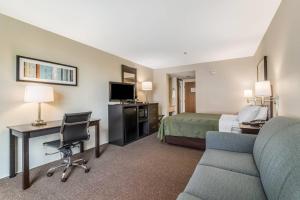 Habitación de hotel con cama, escritorio y sofá en Quality Inn, en Portsmouth