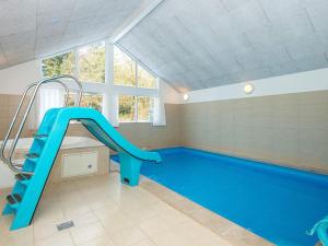a swimming pool with a blue slide in a room at Luxury Pool Retreat in Henne - By Traum Ferienwohnungen in Henne Strand