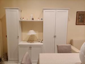 a room with white cabinets and a table with a lamp at La Fenice in Mola di Bari