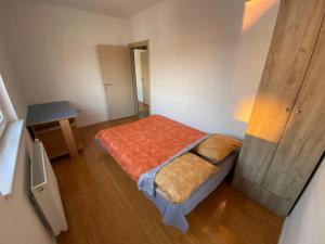 a small bedroom with a bed and a table at Panoramic View Apartment in Kragujevac