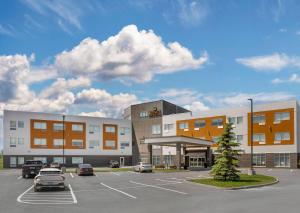 un parking avec des voitures garées devant un bâtiment dans l'établissement Quality Inn & Suites, à Mont-Joli