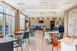 une salle à manger avec tables, chaises et fenêtres dans l'établissement Quality Inn & Suites, à Mont-Joli