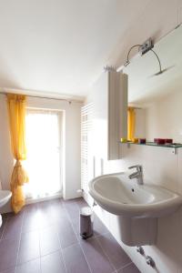 a white bathroom with a sink and a window at Residenza le Torri in Cavaion Veronese