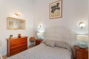 a bedroom with a bed and a dresser and a mirror at Maspalomas Green Oasis in San Bartolomé de Tirajana +17 photos