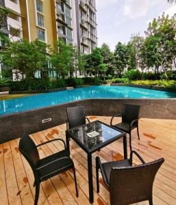 a patio with a table and chairs and a swimming pool at NearEcobotanic & Legoland-HappyMoonlight-2B2R-8px in Iskandar Puteri