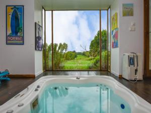a large bath tub in a room with a large window at Hilltop Haven in Parlan in Le Sartre