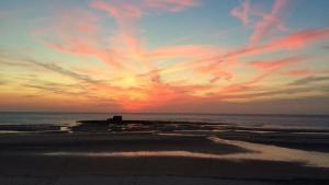 a sunset on a beach with the ocean at Chez Julie & Yvon in Le Portel +5 photos