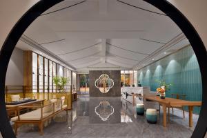a rendering of a lobby with tables and chairs at hanghzou moshangqingya hotel in Libu