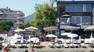 eine Gruppe von Menschen, die am Strand mit Sonnenschirmen sitzen in der Unterkunft En Vie Beach Boutique Hotel - Adults Only in Alanya