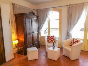 a living room with two chairs and a cabinet at Villetta Romantica in Verbania