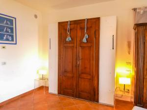 a large wooden door in a room with a tile floor at Villetta Romantica in Verbania