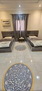 two beds in a room with two rugs on the floor at شقة مفروشة للإيجار جدة حى الريان in Jeddah