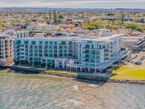 an aerial view of a building next to the water at The Top Deck Retreat Ballina in Ballina