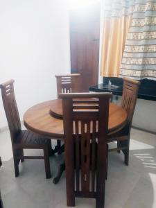 a wooden table with four chairs and a table and a piano at Misty Morning Villa - Ella in Medaperuwa +12 photos