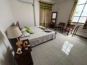 une chambre avec un lit et une table avec une lampe dans l'établissement Green Woods, à Colombo