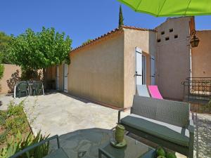 a patio with a bench and an umbrella at Saint-Maximin Pool & Peace in Saint-Maximin