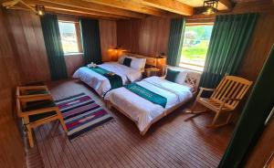 ein Schlafzimmer mit zwei Betten, einem Stuhl und einem Fenster in der Unterkunft Wanderlust Chapter 1 in Arangkēl