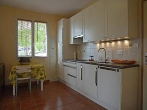 a kitchen with white cabinets and a table in it at House in Piquecos with Private Pool & Garden in Piquecos