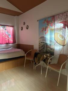 une chambre avec deux chaises, un lit et un tableau dans l'établissement NAPA CHATEAU Resort, à Ban San Khu 11 autres photos