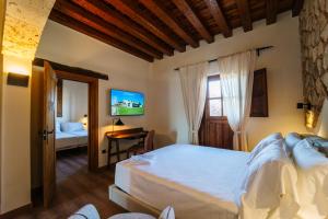 a bedroom with a large bed and a desk at Abba las Viñas Tiedra in Tiedra