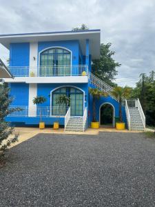 une maison bleue avec des escaliers blancs devant elle dans l'établissement NAPA CHATEAU Resort, à Ban San Khu