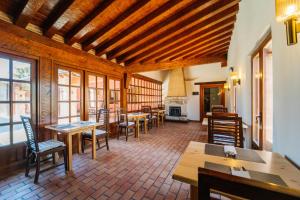 a restaurant with tables and chairs and a fireplace at Abba las Viñas Tiedra in Tiedra