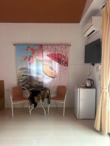 une pièce avec deux chaises et un tableau de parapluies dans l'établissement NAPA CHATEAU Resort, à Ban San Khu