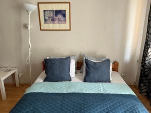 ein Schlafzimmer mit einem Bett mit blauen Kissen in der Unterkunft Apartment Stepana Bandery Street in Riwne