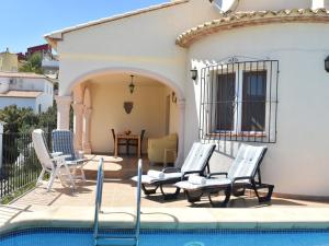a group of chairs sitting next to a swimming pool at Peaceful Villa with Private Pool in Adsubia