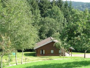 a small wooden cabin in a field with trees at Ventron Chalet with Hill Views in Ventron