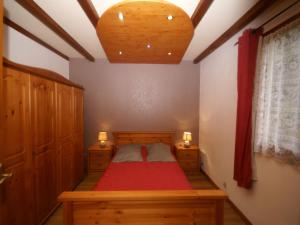 a bedroom with a red bed and two dressers at Ventron Chalet with Hill Views in Ventron