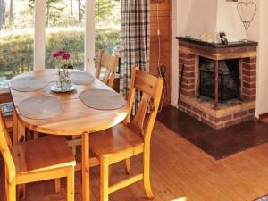 a wooden table and chairs in a room with a fireplace at 4 person holiday home in Ulfborg-By Traum in Fengersfors
