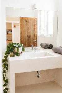 Un baño con un lavabo blanco y un espejo. en Canggu Family Villa Pool Fence Available, en Canggu