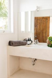 Un baño blanco con lavabo y espejo. en Canggu Family Villa Pool Fence Available, en Canggu 19 fotos más