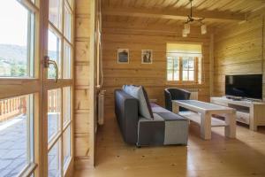 a living room with a couch and a tv at Mosorny Park Drewniane Komfortowe Domki Całoroczne in Zawoja