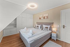 a bedroom with a large white bed with white sheets at Ferienhüs Keitumliebe in Keitum