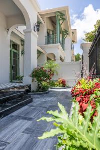 a white house with plants in front of it at S-Solution Villa Phu Quoc by DDH in Phu Quoc