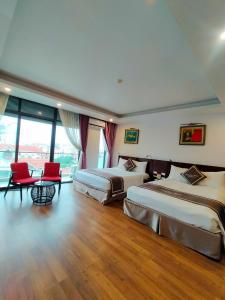 a hotel room with two beds and red chairs at Camellia Hotel in Ninh Binh