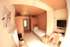 une petite chambre avec un lit et une télévision dans l'établissement Hotel Schmid, à Bad Bellingen